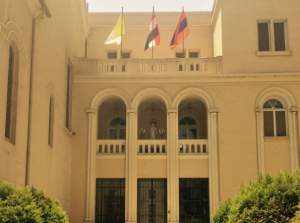 The flags (left to right) of the Vatican, Egypt, and Armenia hang above the offices of the Armenian Catholic Cathedral in downtown Cairo.